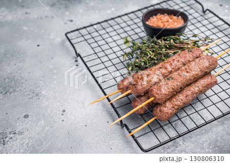 BBQ Roasted beef and lamb meat kebabs sausages, kofta kebab. grey background. top view BBQ Roasted beef and lamb meat kebabs sausages, kofta kebab. grey background. top view 130806310