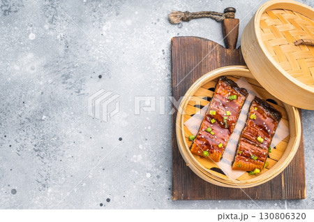 Unagi eel, Japanese grilled eel with sweet soy sauce. grey background. top view Unagi eel, Japanese grilled eel with sweet soy sauce. grey background. top view 130806320