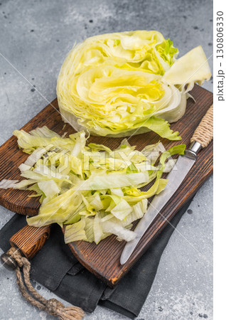 Fresh green iceberg lettuce salad sliced leaves. grey background. top view Fresh green iceberg lettuce salad sliced leaves. grey background. top view 130806330