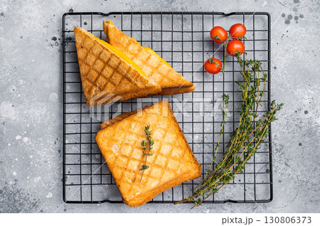 Grilled cheese sandwich on steel rack. grey background. top view Grilled cheese sandwich on steel rack. grey background. top view 130806373
