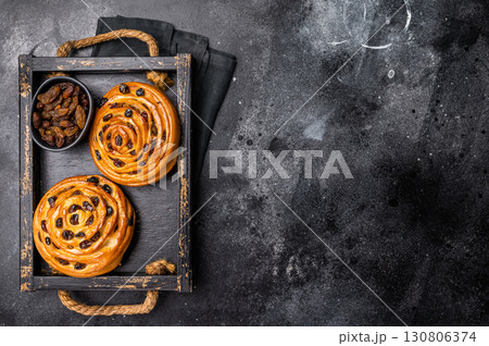 Danish raisin pastry swirls. black background. top view Danish raisin pastry swirls. black background. top view 130806374