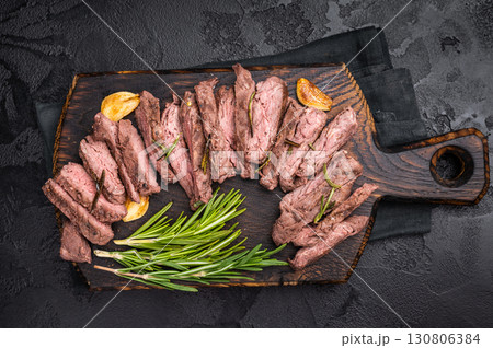 Roast Skirt Machete Steak, grilled beef meat on cutting board. black background. top view Roast Skirt Machete Steak, grilled beef meat on cutting board. black background. top view 130806384