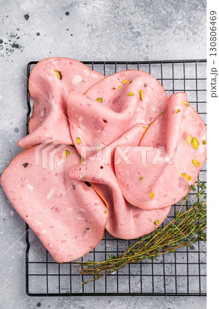 Slices Of Traditional Italian antipasti mortadella Bolognese. grey background. top view Slices Of Traditional Italian antipasti mortadella Bolognese. grey background. top view 130806469