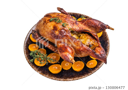 Roast goose with apples and oranges on plate with herbs isolated on white background. top view Roast goose with apples and oranges on plate with herbs isolated on white background. top view 130806477