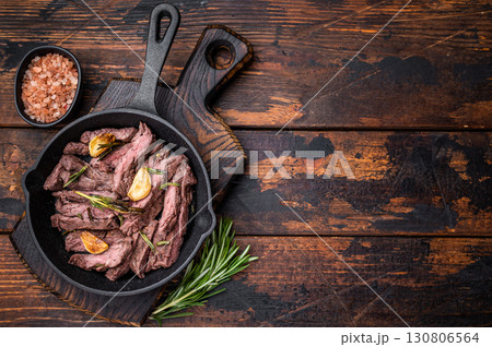 Grilled and sliced Beef top sirloin Steak in a pan. wooden background. top view Grilled and sliced Beef top sirloin Steak in a pan. wooden background. top view 130806564