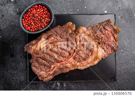 Roasted Chuck eye roll steak, marbled beef meat on a board. black background. top view Roasted Chuck eye roll steak, marbled beef meat on a board. black background. top view 130806570