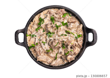 Creamy beef stroganoff with fresh greenery in a skillet isolated on white background. top view Creamy beef stroganoff with fresh greenery in a skillet isolated on white background. top view 130806657