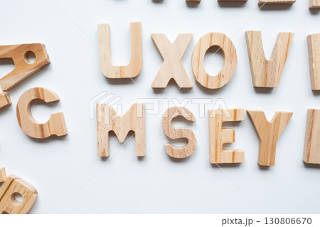 Wooden alphabet letters on white background in random arrangement Wooden alphabet letters on white background in random arrangement 130806670