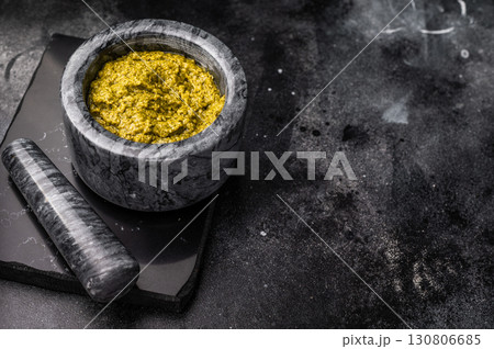 Iitalian spread sauce pesto with green basil in bowl. black background. top view Iitalian spread sauce pesto with green basil in bowl. black background. top view 130806685