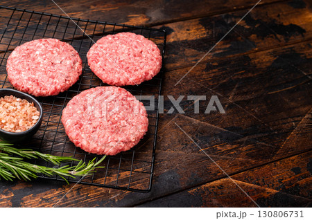 Raw meat patties, cutlets, chopped meat for burgers. wooden background. top view Raw meat patties, cutlets, chopped meat for burgers. wooden background. top view 130806731