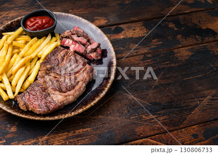 Dinner with grilled Chuck eye roll steak and french fry on a plate. wooden background. top view 130806733