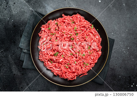Lamb Mutton ground mince raw meat, forcemeat on a black plate, top view. 130806750