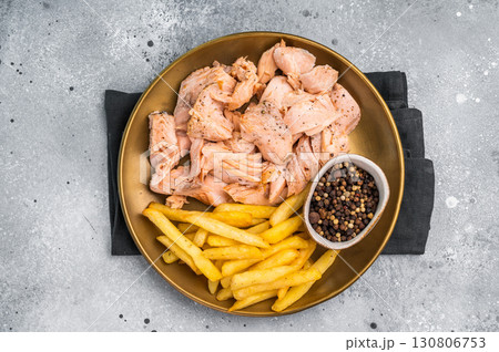 Dinner with Pulled salmon roast fillets and french fry on a plate. gray background. Top view 130806753