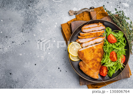 Fried Weiner schnitzel steak, veal breaded meat with salad on a plate. grey background. top view 130806764