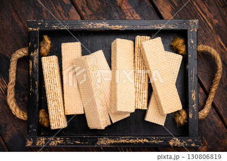 Wafer stick biscuits with vanilla cream in wooden tray. wooden background. top view Wafer stick biscuits with vanilla cream in wooden tray. wooden background. top view 130806819