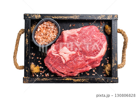 Rib eye steak in wooden tray, raw dry aged prime beef meat isolated on white background Rib eye steak in wooden tray, raw dry aged prime beef meat isolated on white background 130806828