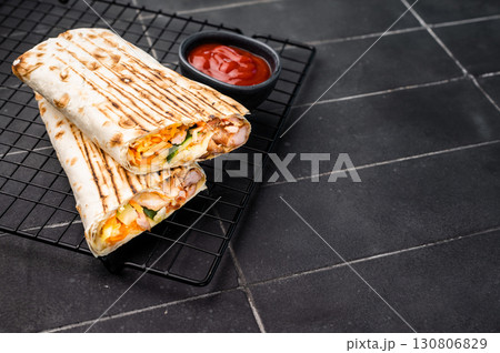 Turkish Shawarma, doner wrap sandwich with meat and salad. black background. top view Turkish Shawarma, doner wrap sandwich with meat and salad. black background. top view 130806829