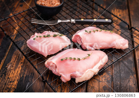 Raw Skinless boneless chicken thighs fillet. wooden background. top view Raw Skinless boneless chicken thighs fillet. wooden background. top view 130806863