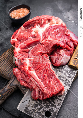 Beautifully marbled raw beef neck meat, perfect for enhancing your favorite recipes with rich flavors. black background. top view Beautifully marbled raw beef neck meat, perfect for enhancing your favorite recipes with rich flavors. black background. top view 130806911