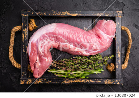 Raw pork tender cut, tenderloin featuring a smooth texture, perfect for creating gourmet dishes at home. black background. top view 130807024