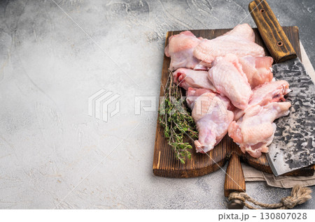 Fresh chicken wings, showcasing their natural texture, perfect for creating savory snacks or hearty meals. white background. top view 130807028