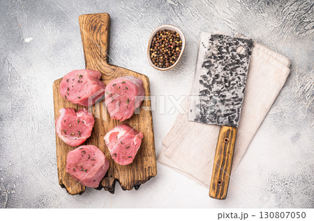 Juicy uncooked pork medallion, raw loin meat a versatile choice for stir fries or savory roasts in any cuisine. white background. top view 130807050