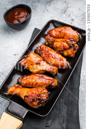 Juicy barbecue chicken wings, perfectly grilled and glazed, ideal for your next summer cookout or party. grey background. top view 130807058