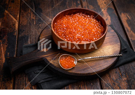 Delightful red caviar, a symbol of luxury and sophistication, ready to impress at your next gathering. wooden background. top view Delightful red caviar, a symbol of luxury and sophistication, ready to impress at your next gathering. wooden background. top view 130807072