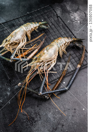 Fresh raw rosenbergii shrimp prawn, perfect for gourmet dishes and seafood lovers seeking premium quality.black background. top view Fresh raw rosenbergii shrimp prawn, perfect for gourmet dishes and seafood lovers seeking premium quality.black background. top view 130807088