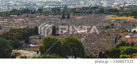 Aerial view of Pompeii's ancient ruins, featuring stone structures, streets, an amphitheater, and modern buildings in the background. Aerial view of Pompeii's ancient ruins, featuring stone structures, streets, an amphitheater, and modern buildings in the background. 130807335