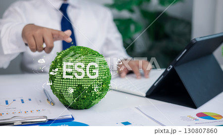 Businessman working on ESG sustainability concept with green globe and environmental icons 130807860