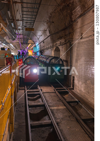 Underground view of the London Postal Museum's Mail Rail featuring red and green trains on tracks, arched brick walls, and modern lighting. Underground view of the London Postal Museum's Mail Rail featuring red and green trains on tracks, arched brick walls, and modern lighting. 130807987