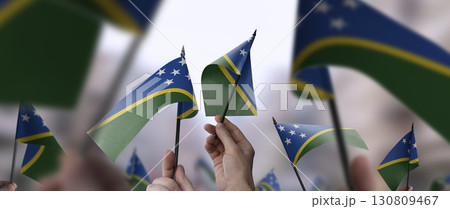 Solomon flags in their hands on a blurred urban background 130809467