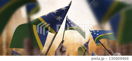 Solomon flags in their hands on a blurred urban background 130809468
