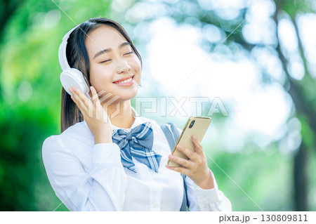 音楽を聴く女子学生 130809811
