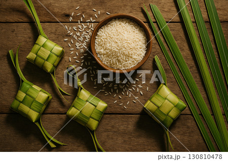 Ketupat displayed on green leaves with cultural Eid festive rustic setting. Eid celebration concept 130810478