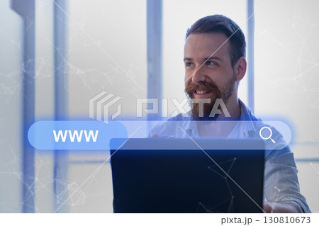 Smiling man in office searching online with laptop during daytime Smiling man in office searching online with laptop during daytime 130810673