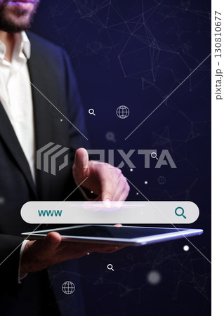Business professional interacts with digital tablet in dark space representing online search Business professional interacts with digital tablet in dark space representing online search 130810677