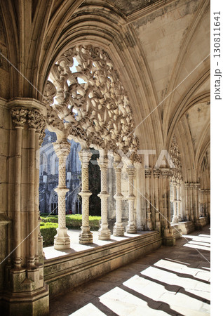 Intricate stone arches and columns in the beautiful cloister at Batalha monastery 130811641