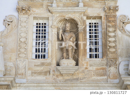 Stone sculpture of a figure with an umbrella on Coimbra University facade Stone sculpture of a figure with an umbrella on Coimbra University facade 130811727