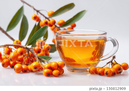 Sea buckthorn tea. Hot healing berry drink with honey for the winter or fall season. Nutritious autumn vitamin beverage with fresh berries and leaves isolated on white surface. Warm beneficial drink 130812909