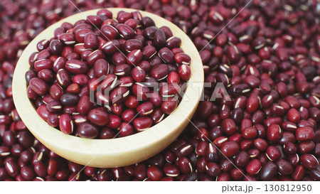 Closeup of raw red adzuki beans in a wooden bowl placed on a pile of beans background. Perfect for illustrating healthy food Closeup of raw red adzuki beans in a wooden bowl placed on a pile of beans background. Perfect for illustrating healthy food 130812950