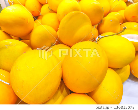 This is a close-up photo of various pickled fruits and vegetables, including mango, plums, and other items, stored in transparent plastic containers and displayed for sale. 130813078