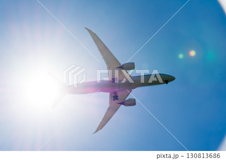 まぶしい太陽と青空の下を通過していく旅客機 ロンドン郊外のヒースロー空港近くにて まぶしい太陽と青空の下を通過していく旅客機 ロンドン郊外のヒースロー空港近くにて 130813686