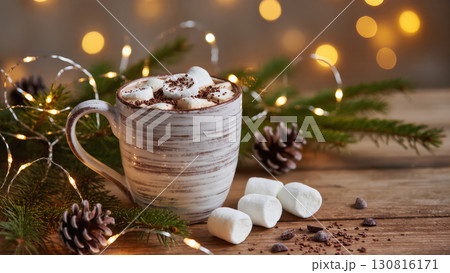 Christmas hot chocolate with marshmallows and chocolate shavings in rustic mug on wooden table with pine branches and festive lights Christmas hot chocolate with marshmallows and chocolate shavings in rustic mug on wooden table with pine branches and festive lights 130816171