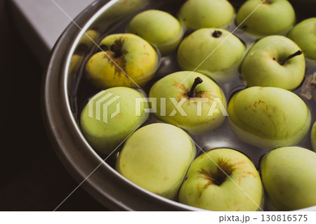 Fresh green apples in bowl. Ripe apples in water. Autumn harvest. Organic fruits background. Heap of green apples. Raw dieting. Natural vitamin. Healthy eating concept. Natural snack. 130816575