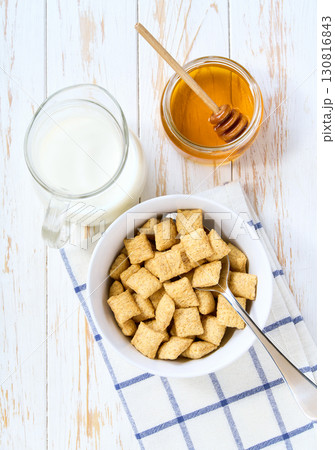 bowl of tasty corn pillows with milk and honey on a light kitchen table.Top view. bowl of tasty corn pillows with milk and honey on a light kitchen table.Top view. 130816843