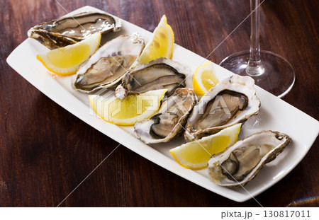 Tasty oysters with lemon on plate top view Tasty oysters with lemon on plate top view 130817011