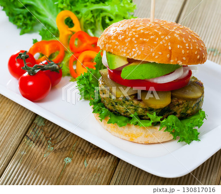 Vegetarian hamburger with soybean cutlet, tomato, avocado and lettuce Vegetarian hamburger with soybean cutlet, tomato, avocado and lettuce 130817016