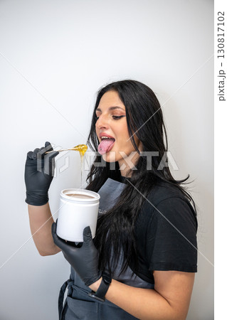 Beautician woman in black gloves holding jar of sugaring paste for hair removal procedure Beautician woman in black gloves holding jar of sugaring paste for hair removal procedure 130817102